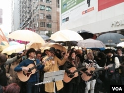 香港流行歌手黃耀明（穿黃色大衣）與何韻詩及多位音樂人，聖誕日在旺角行人專 區街頭演唱，呼籲市民延續雨傘運動精神，繼續爭取真普選