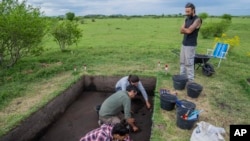 Arqueólogos excavan en el sitio de un montículo de tierra indígena conocido como "cerritos de indios", cerca de Villa Ansina, Uruguay, el 2 de noviembre de 2021. 