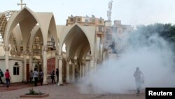 Coptic Christians run inside the main cathedral in Cairo as police fire tear gas during clashes with Muslims in this April 7, 2013, file photo.