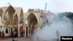 Coptic Christians run inside the main cathedral in Cairo as police fire tear gas during clashes with Muslims standing outside the cathedral April 7, 2013.