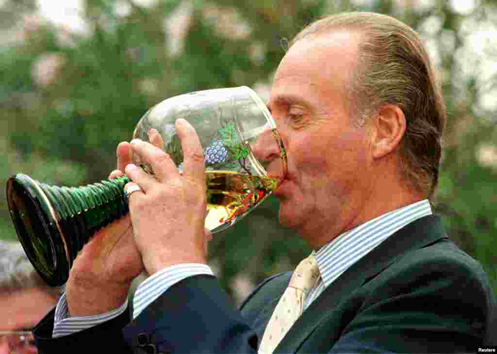 Raja Spanyol Juan Carlos meminum anggur dari gelas tradisional besar dari wilayah Jerman, Rhineland-Palatinate dalam sebuah kunjungan ke Deidesheim, Jerman, 17 Juli 1997.