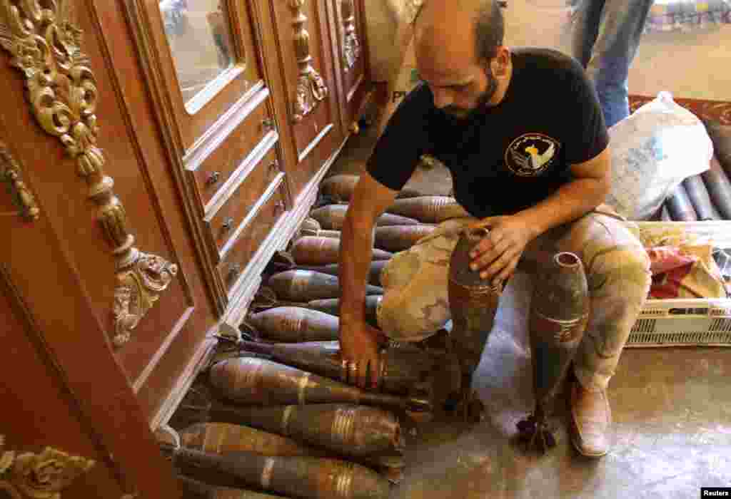 A Free Syrian Army member handles mortar shells inside a house in the old city of Aleppo, Sept. 10, 2013. 