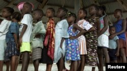 FILE - Liberian children queue for their measles vaccinations in an International Rescue Committee clinic in Monrovia, August 26, 2003.