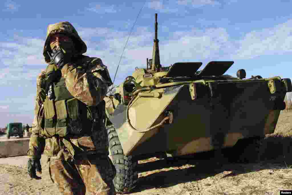 A Ukrainian serviceman guards a checkpoint near the village of Strelkovo in Kherson region adjacent to Crimea, March 17, 2014.