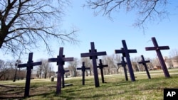 FILE - In this April 19, 2018 file photo, crosses representing victims of gun violence stand outside Collins Academy High School in Chicago's North Lawndale neighborhood. 