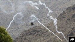 A helicopter belonging to the NATO-led forces fires flares during fighting between the Afghan and foreign troops and the Taliban insurgents in Shewa district of Nanagarhar province, July 17, 2011