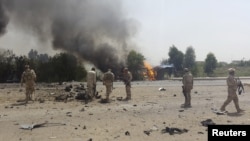 Iraqi security forces inspect the site of a car bomb attack on the outskirts of Diyala province, May 24, 2015. 