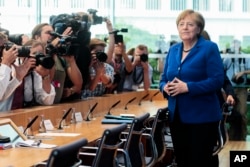 FILE - German Chancellor Angela Merkel, right, arrives for a news conference in Berlin, July 28, 2016. Merkel has not responded to taunts that she would lose reelection by U.S. presidential candidate Donald Trump.
