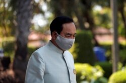 Thailand's Prime Minister Prayut Chan-o-cha wears a protective mask due to the COVID-19 outbreak, as he comes out from a meeting at Government House in Bangkok on March 24, 2020.