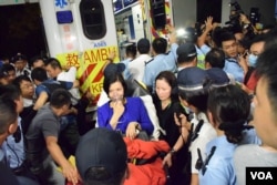 港大校務委員劉麥嘉軒(坐擔架者)在停車場被抗議人士包圍，混亂中報稱無法呼吸，由救護車送院檢查，其間一批警員進入港大校園護送。(美國之音湯惠芸)