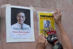 An activist pastes images of Thai dissident Wanchalearm Satsaksit on a wall near Cambodian Embassy in Bangkok, Thailand, Monday, June 8, 2020. (AP Photo)