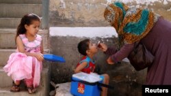 A boy receives polio vaccine drops during an anti-polio campaign, in a low-income neighbourhood in Karachi, Pakistan, April 9, 2018. 