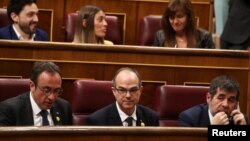 FILE - Jailed Catalan politicians Jordi Sanchez, Josep Rull and Jordi Turull attend the first session of parliament following a general election in Madrid, Spain, May 21, 2019.