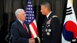 El vicepresidente Mike Pence, da la mano al general estadounidense Vincent Brooks, comandante del Comando de las Naciones Unidas, de las Fuerzas de EE.UU. Corea y del Comando de Fuerzas Combinadas en Seúl, Corea del Sur, domingo, 16 de abril de 2017.