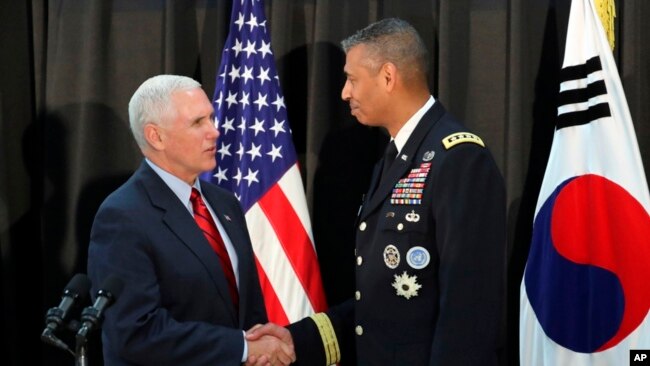 El vicepresidente Mike Pence, da la mano al general estadounidense Vincent Brooks, comandante del Comando de las Naciones Unidas, de las Fuerzas de EE.UU. Corea y del Comando de Fuerzas Combinadas en Seúl, Corea del Sur, domingo, 16 de abril de 2017.