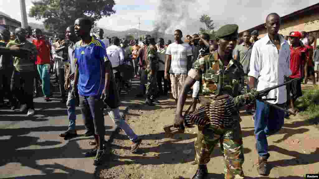Un soldat armé d&#39;une mitrailleuse, se déploie devant un groupe des manifestants qui ont des escarmouches avec la police anti-émeute, lundi 27 avril à Bujumbura, Burundi.