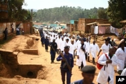 FILE - Doctors and health workers march in the Eastern Congo town of Butembo on April 24, 2019, after attackers shot and killed an epidemiologist from Cameroon who was working for the World Health Organization. Doctors at the epicenter of Congo's Ebola crisis have threatened to go on strike indefinitely if health workers are attacked again.