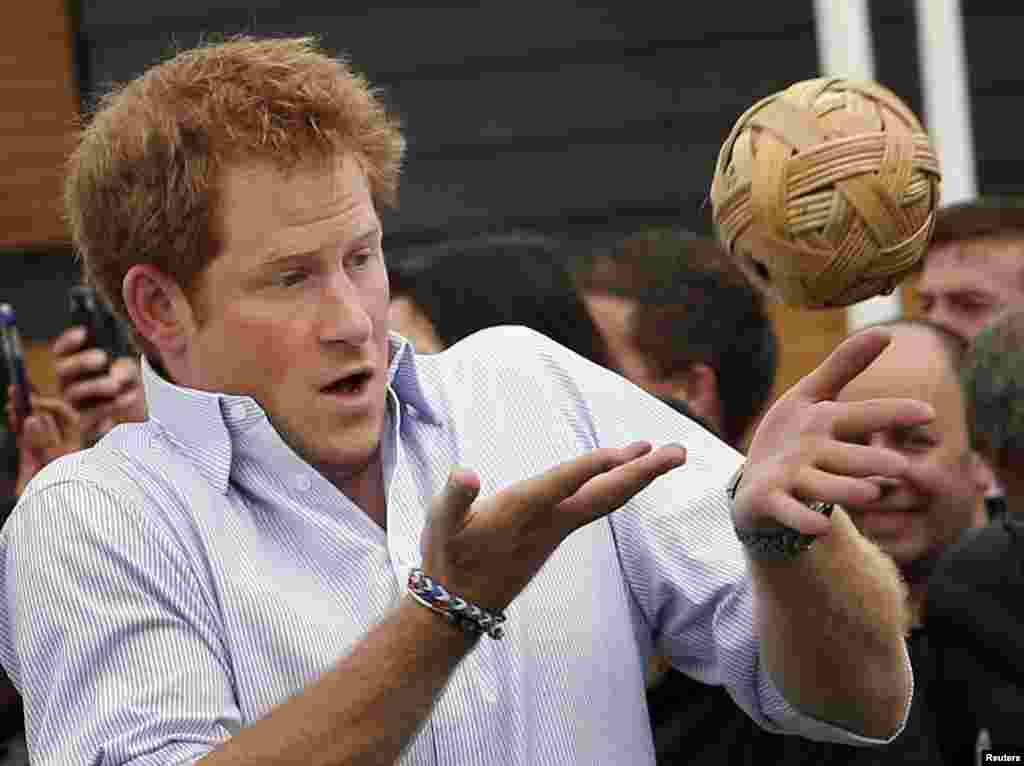 Britain&#39;s Prince Harry plays with a ball during a visit to the Commonwealth Games Village at the 2014 Commonwealth Games in Glasgow, Scotland.