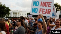 People gather for a vigil in response to the death of a counter-demonstrator at the "Unite the Right" rally in Charlottesville, outside the White House in Washington, Aug. 13, 2017. 