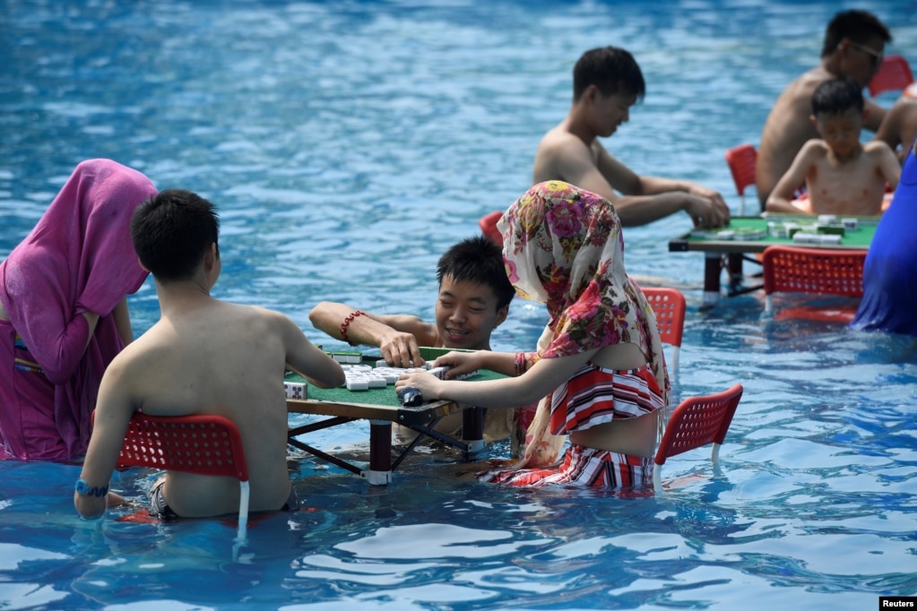 在中国重庆，炎热的一天，人们在水上公园玩麻将。（2017年8月2日）