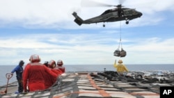 En esta foto de 2011, marineros del USNS Rappahannock llevan ayuda humanitaria a las víctimas del terremoto de Japón. Este mismo buque disparó este lunes a una embarcación sospechosa, en el golfo Pérsico.
