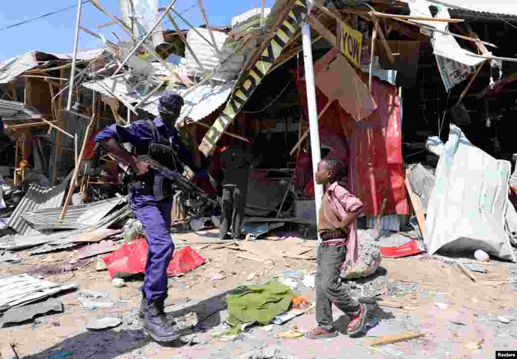 A Somali security officer secures the scene of an explosion at a market in Wadajir district in Mogadishu.