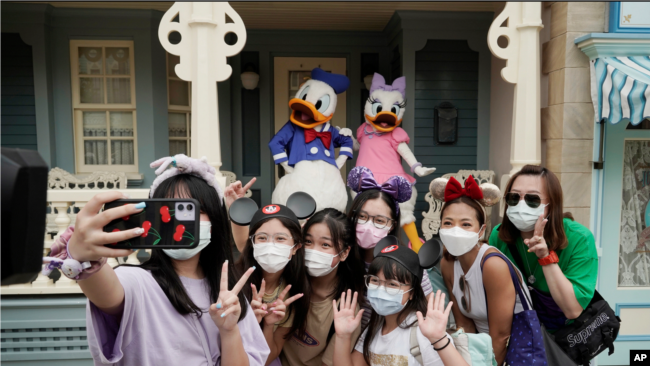 Vizitorët në Disneyland bëjnë fotografi me personazhet e mirënjohur të filmave vizatimorë (Hong Kong, 25 shtator 2020)