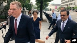 United States Trade Representative Robert Lighthizer, left, and Mexican Secretary of Economy Idelfonso Guajardo, right, walk to the White House, in Washington, Aug. 27, 2018.