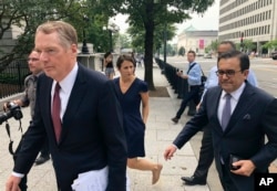 United States Trade Representative Robert Lighthizer, left, and Mexican Secretary of Economy Idelfonso Guajardo, right, walk to the White House, in Washington, Aug. 27, 2018.