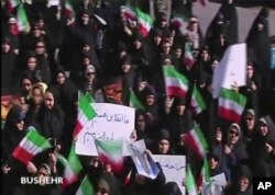 This frame grab from video provided by Iran Press, a pro-government news agency based in Beirut, shows pro-government demonstrators marching in Bushehr, Iran, Jan. 3, 2018.