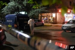 FILE - A police investigator inspects the scene where an unidentified assailant shot and wounded journalist Olivera Lakic in Montenegro's capital, Podgorica, May 8, 2018. Lakic is known for her reporting on crime and corruption in the small Balkan country.