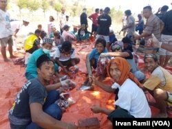 Pengungsi berkumpul mengurus daging kurban di pos pengungsian lapangan Mentigi, Lombok Utara, Rabu 22 Agustus 2018. (Foto:VOA/Irvan Ramli)