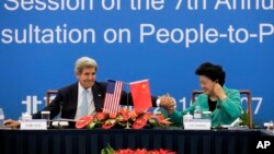 U.S. Secretary of State John Kerry, left, holds the hand of Chinese Vice Premier Liu Yandong after delivering a speech for the plenary session of the 7th annual U.S.-China High-Level Consultation on People-to-People Exchange.