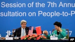 U.S. Secretary of State John Kerry, left, holds the hand of Chinese Vice Premier Liu Yandong after delivering a speech for the plenary session of the 7th annual U.S.-China High-Level Consultation on People-to-People Exchange at the National Museum in Beijing, June 7, 2016.