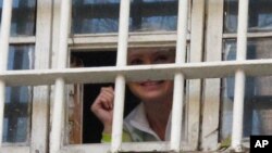 Mantan Perdana Menteri Ukraina Yulia Tymoshenko terlihat tersenyum dari balik teralis penjara di Kiev, Ukraina (Foto: dok). Tymoshenko tidak bersedia menghentikan aksi mogok makannya, sebagai bagian dari protes atas pelanggaran dalam pemilu parlemen di negara itu.
