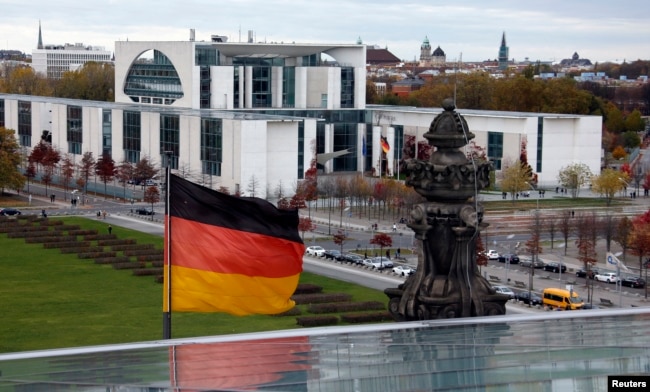 FILE - A German national flag flutters in front of the Chancellery in Berlin. The 2013 revelation that the U.S. National Security Agency had tapped German Chancellor Angela Merkel's mobile phone came from WikiLeaks.
