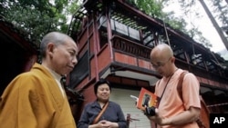作家廖亦武2006年在一座被四川地震破壞的寺廟前和守寺人與僧人交談