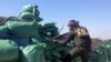 FILE - A member of the tribal groups fighting along with the Iraqi government security forces takes a position behind sandbags during clashes with jihadists in the Hosh district of Ramadi as the Islamic State jihadist group launched a coordinated attack on government-held areas of the western Iraqi city, March 11, 2015.