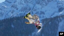 United States' Sage Kotsenburg takes jump during men's snowboard slopestyle final, Rosa Khutor Extreme Park, 2014 Winter Olympics, Sochi, Feb. 8, 2014.