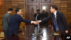 韩国首席谈判代表金基雄（右）星期四在板门店朝鲜一侧与朝鲜首席谈判代表握手。（2015年11月26日 韩国统一部提供照片）