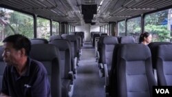 Two passengers sit inside one of the carts as the Phnom Penh airport shuttle is heading to its destination. (Bun Sokha/VOA Khmer)