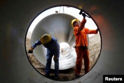 Workers put together a pipeline during the construction of the Olmos Irrigation Project in Lambayeque, March 15, 2013.