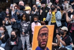 Demonstrators gather for a solidarity rally lead by community organizers in the Black and Asian communities in memory of George Floyd and Daunte Wright outside Cup Foods, Sunday, April 18, 2021, in Minneapolis. (AP Photo/John Minchillo)