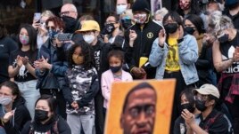 Demonstrators gather for a solidarity rally lead by community organizers in the Black and Asian communities in memory of George Floyd and Daunte Wright outside Cup Foods, Sunday, April 18, 2021, in Minneapolis. (AP Photo/John Minchillo)