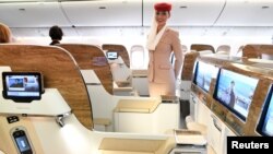 A stewardess of Emirates Airlines stands in the first-class section during a presentation of Emirates' Boeing 777 at the airport in Hamburg, April 11, 2018. The Dubai-based airline has already introduced virtual windows in the first-class suites of its newest planes. 