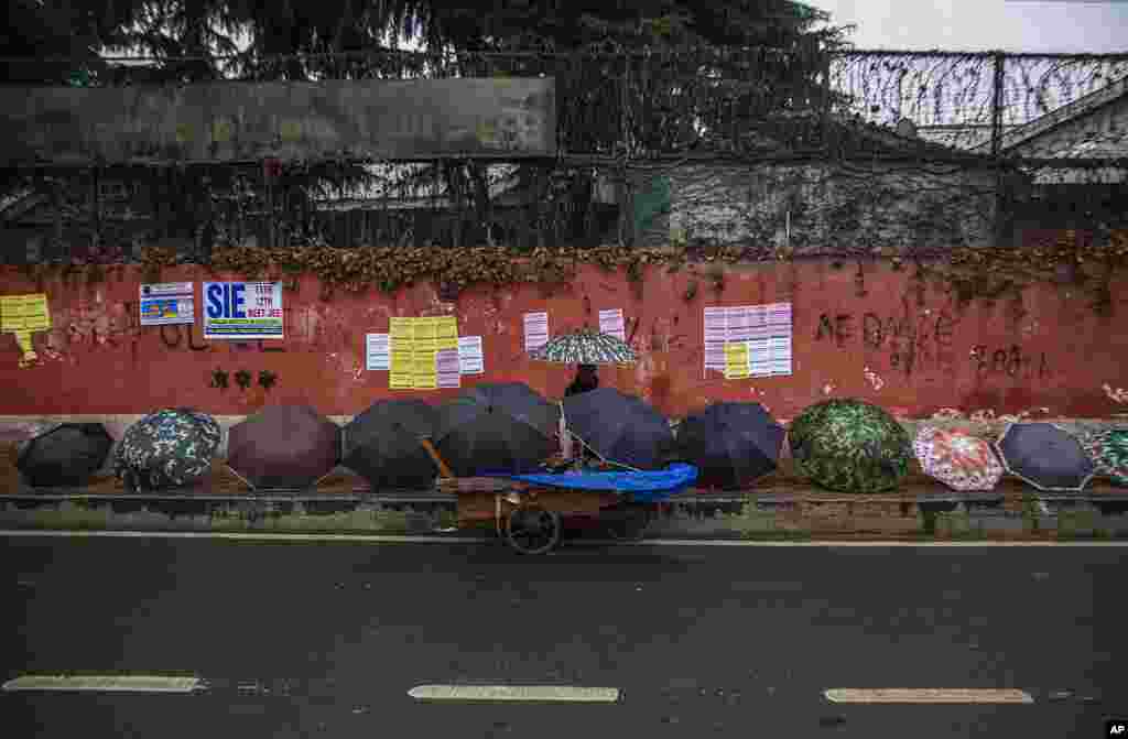 A Kashmiri man sells umbrellas on a pavement as it rains in Srinagar, Indian-controlled Kashmir.