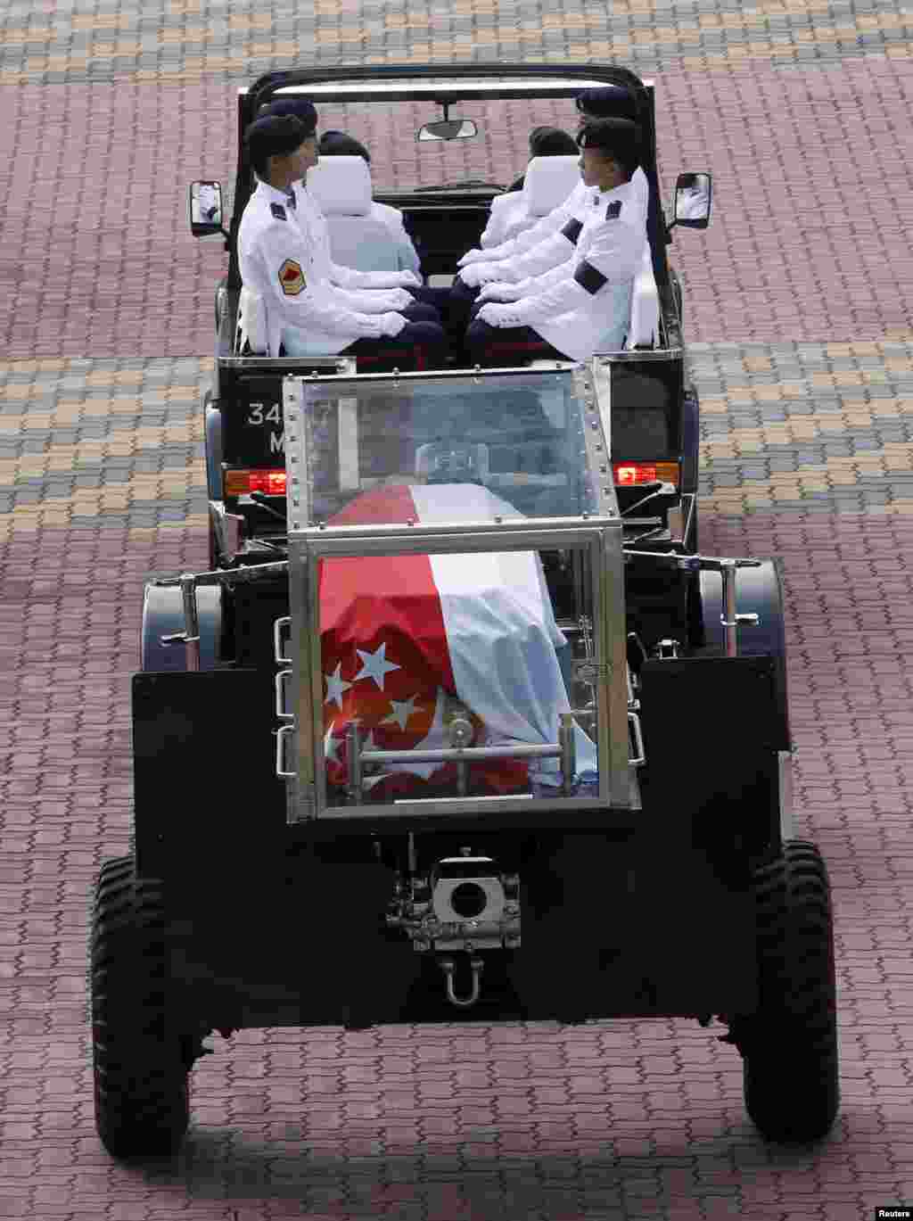 Kendaraan terbuka yang membawa jenazah perdana menteri pertama Singapura tiba di Gedung Parlemen tempat ia akan disemayamkan sampai Sabtu di Singapura (25/3).