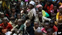 FILE - Refugees who fled Burundi's violence and political tension wait to board a ship freighted by the United Nations, at Kagunga on Lake Tanganyika, Tanzania, May 23, 2015.