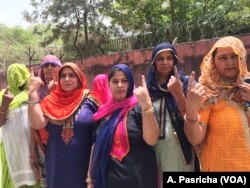 Women emerge from a polling booth in Haryana after casting their votes.