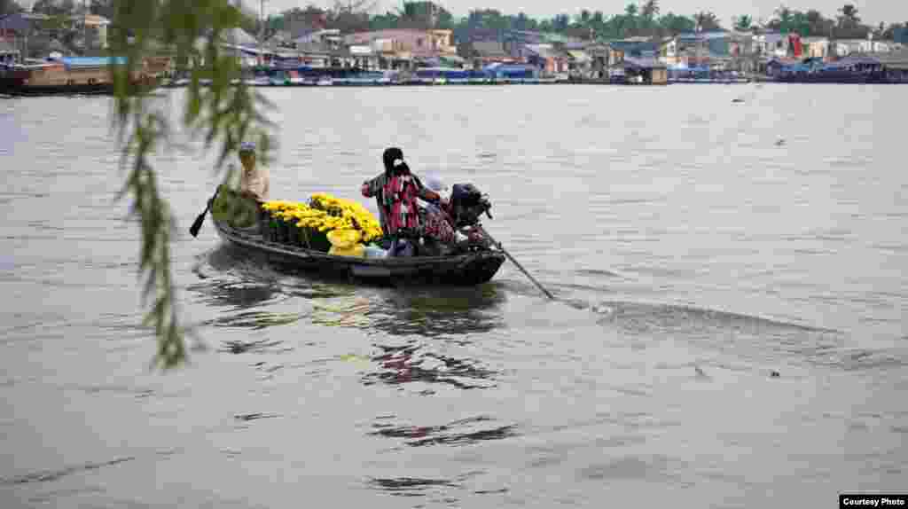 Warga menyeberangi sungai di sebuah perahu kayu di Ninh Kieu distrik Can Tho di wilayah Delta Mekong, Vietnam (Foto oleh Dungvo / Vietnam / pembaca VOA)